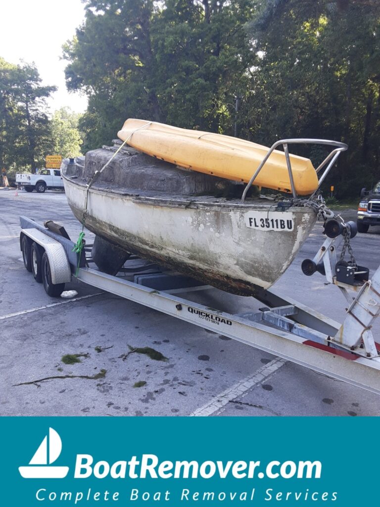 Red tagged sailboat on land in route to salvage yard Hudson Florida